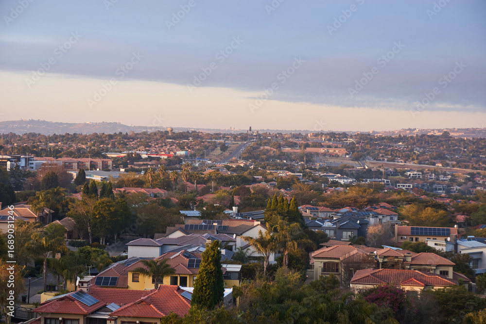 Obraz premium Aerial view of Johannesburg city centre at sunrise, South Africa. The skyline is bathed in warm morning light with urban streets, and a vibrant city atmosphere representing modern Africa.