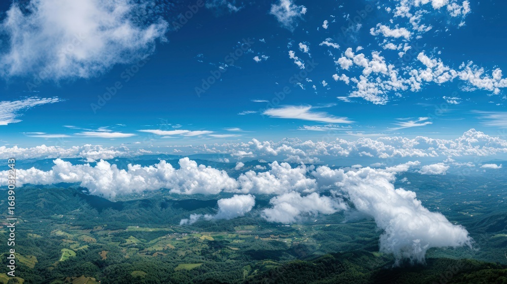 Obraz premium Expansive sky over a lush landscape, adorned with puffy clouds on a bright, sunny day