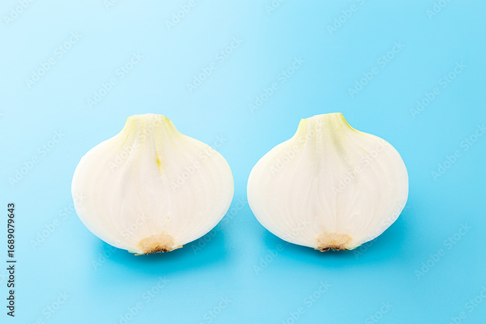 Obraz premium 半分に切った新玉ねぎの断面 水色背景