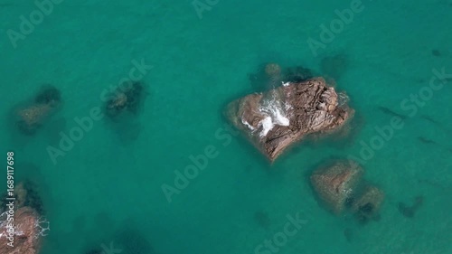 Aerial Drone View of Rocky Outcrop Surrounded by Transparent Mediterranean Water