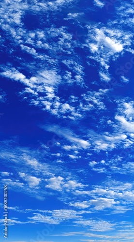 Vertical view of a brilliant blue sky filled with small, puffy white clouds that create a textured, patterned aesthetic, conveying openness and tranquility