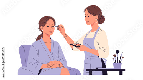 Professional makeup artist applying eye makeup to a client in a salon setting with brushes and palette