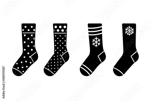 Four black silhouette socks with white patterns including polka dots stripes and snowflakes on white background