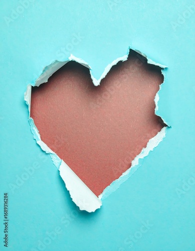 Heart-shaped hole in light blue paper