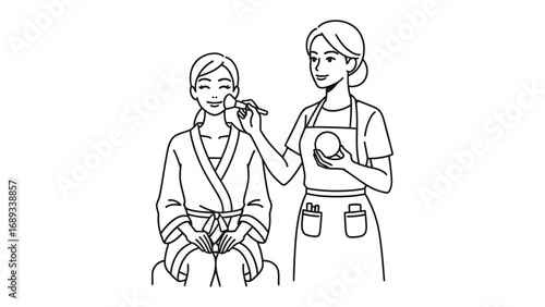 Professional makeup artist applying cosmetics to a client wearing a spa robe and hair towel