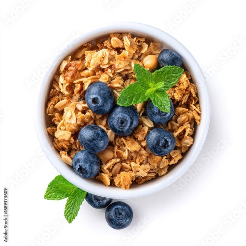 Top-down view of granola in a bowl with blueberries and mint