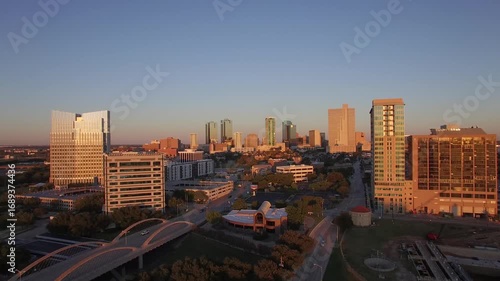 Drone View of Busy Road Bridge and Tall Urban Buildings in Fort Worth Texas With Orange Reflection From the Sunset Sky