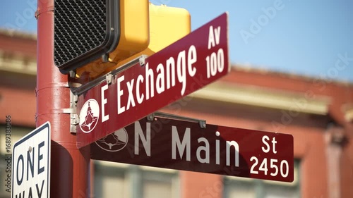 Close Up of E Exchange Avenue and N Main Street Road Signs on Crosswalk Light in Fort Worth, Texas