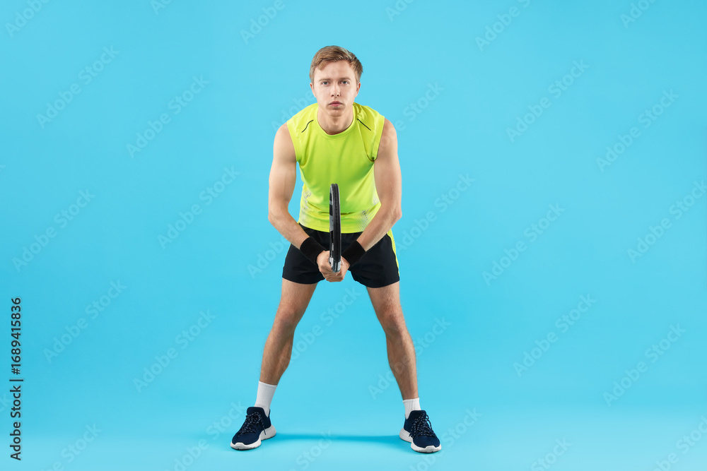 Obraz premium Man with tennis racket on light blue background