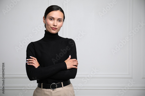 Slika na platnu Portrait of beautiful woman near white wall. Space for text