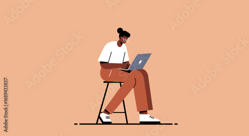 An focused individual sits on a stool, diligently working on a laptop against a clean background. Ideal for themes of remote work, online learning, productivity, and modern digital lifestyles.