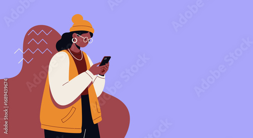 Stylish young woman in a beanie and glasses, focused on her smartphone. Ideal for showcasing digital communication, social media, or online content. Represents modern lifestyle and technology use.