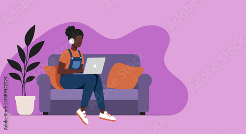 Young woman working remotely on a laptop from a comfortable home sofa, wearing headphones for focused productivity or online learning. Ideal for modern lifestyle and business concepts.