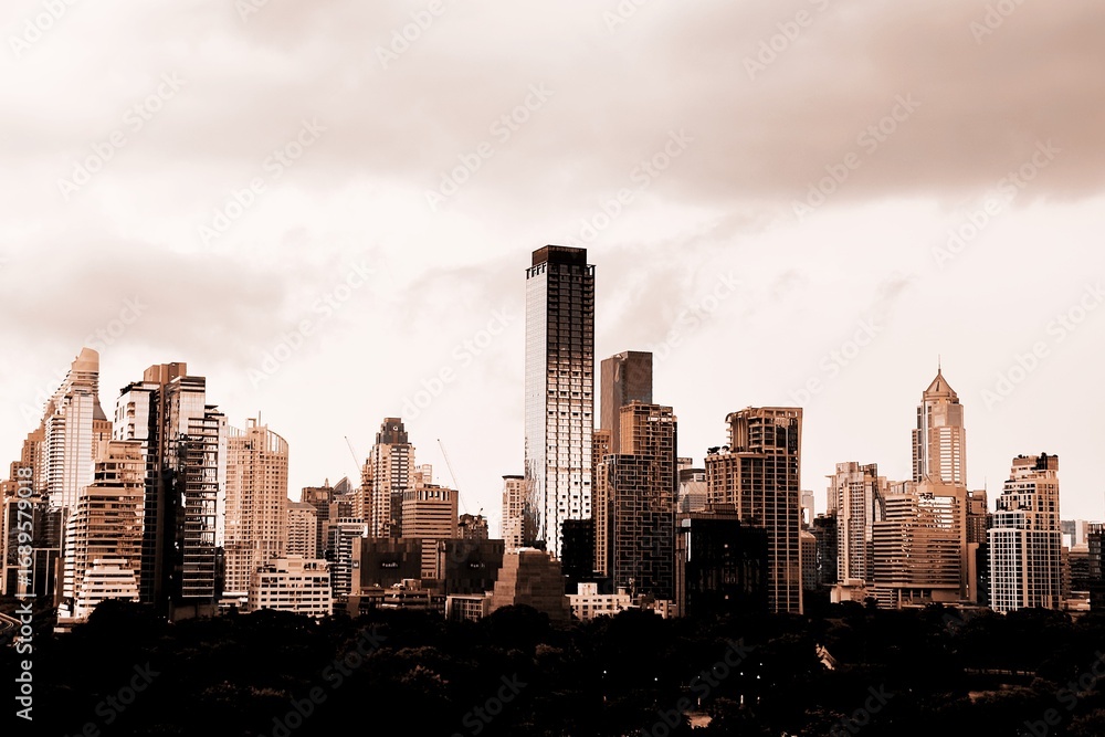 Fototapeta premium A modern city with towering skyscrapers under a dramatic cloudy skyThe sepia tone effect creates an urban and artistic atmosphere perfect for business architecture and cityscape themes Here in Bangkok