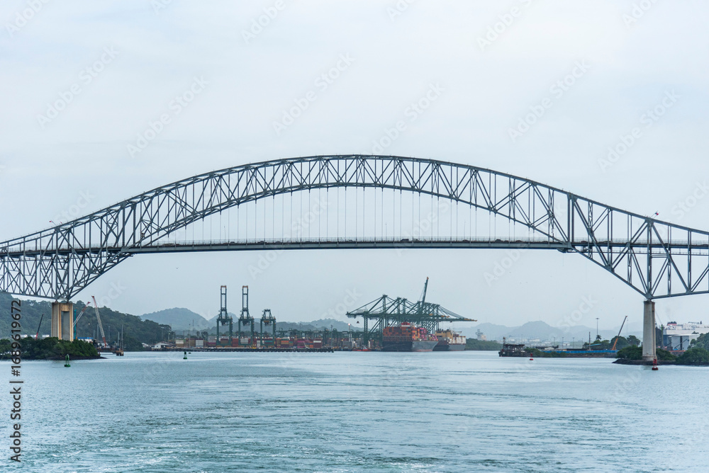 Fototapeta premium Bridge of Americas in Panama spans over a waterway, viewed from a transiting cargo ship.