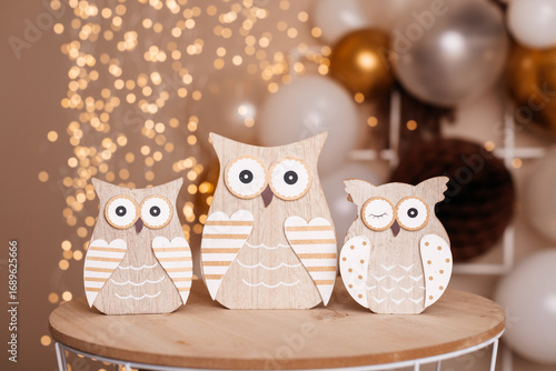 Trio of decorative wooden owls standing on a round wooden base.