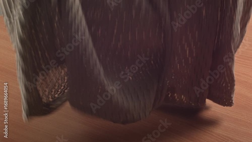 Close-up of woman's hands examining new shorts at home on a table, recorded with ambient sound.