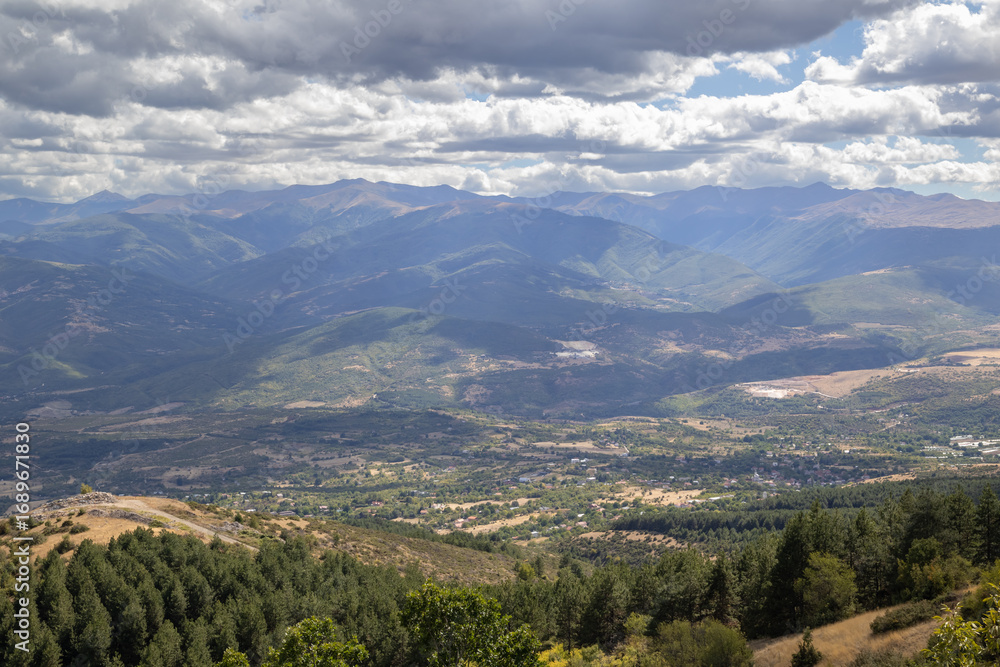 Obraz premium rugged mountain landscape of North Macedonia, with layers of hills and a village nestled in the valley below