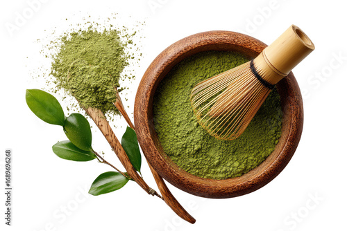 Matcha powder in wooden bowl with whisk and leaves