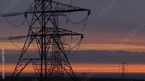 Majestic Power Grid Pylons Stretching Across a Rural English Landscape at Golden Sunrise