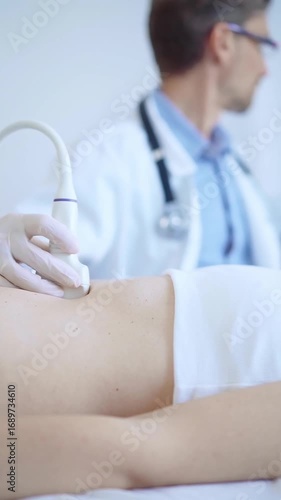 Doctor man wearing a white medical gloves using an ultrasound machine on a female patient examining internal organs. Preventive therapy, medicine