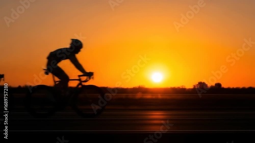 Wallpaper Mural Dynamic Panning Shot of Cyclists Silhouetted Against a Breathtaking Golden Hour Sunset Torontodigital.ca