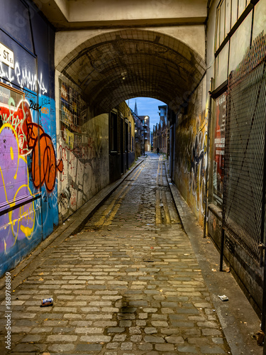 Urban Alleyway with Colorful Graffiti and Brick Arch at Twilight