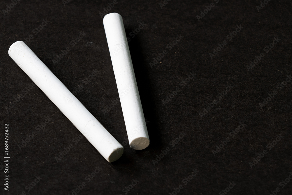 Obraz premium Dos tizas de yeso blanco sobre una superficie oscura