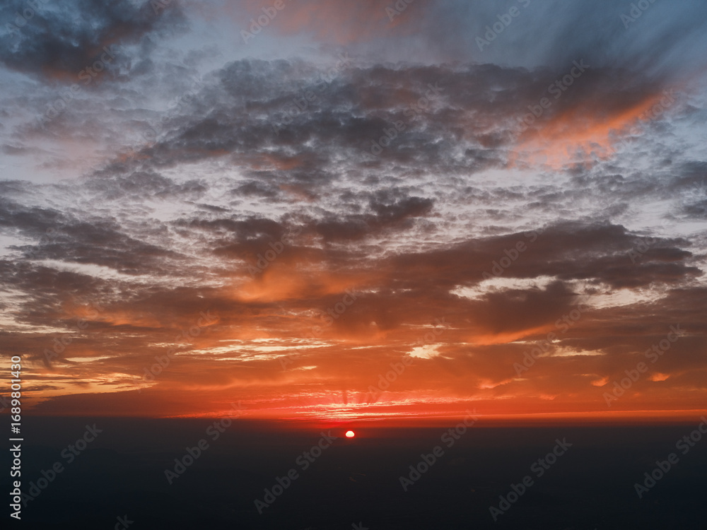 Fototapeta premium Dramatic Sunset Over Horizon with Vibrant Orange and Blue Sky