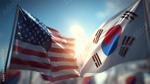 United States and South Korea flags waving together in the wind on a sunny day with a clear blue sky