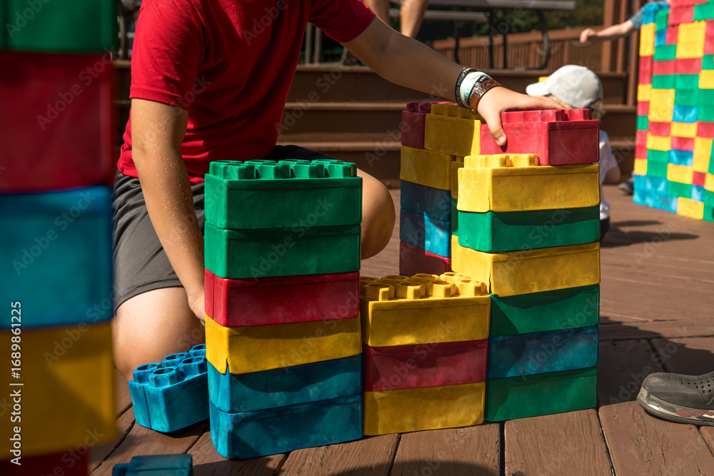 Obraz premium 10-year-old boy building large LEGO outdoors