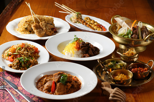 A vibrant and diverse selection of traditional Indonesian cuisine, featuring beef rendang, chicken satay, and nasi goreng beautifully arranged for dining