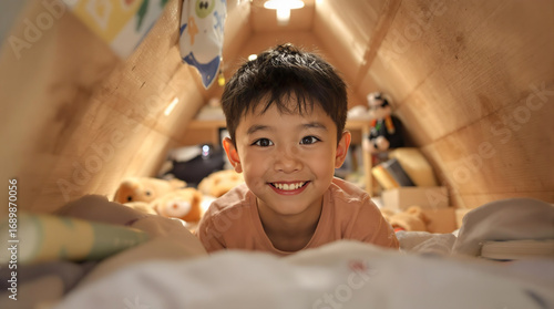 小屋風の秘密基地で楽しそうに笑うアジア人の男の子