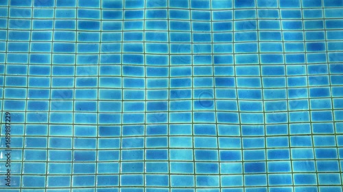 abstract crystal clear to clean blue rippled water and slow motion wave in swimming pool with sunlight by top view for swim travel and vacation exercise at summer and refreshing and sport background