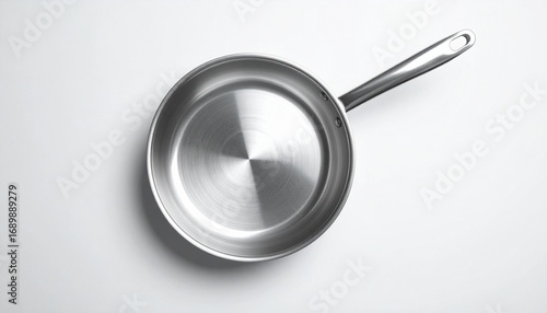 A stainless steel frying pan floating on a white background, photographed from a dramatic top-down angle.