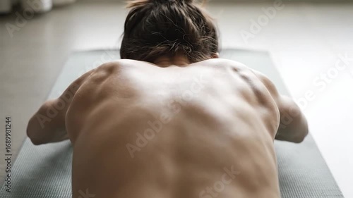 Woman Doing Yoga on Mat, Back View Demonstrating Relaxation and Stress Relief Techniques at Home