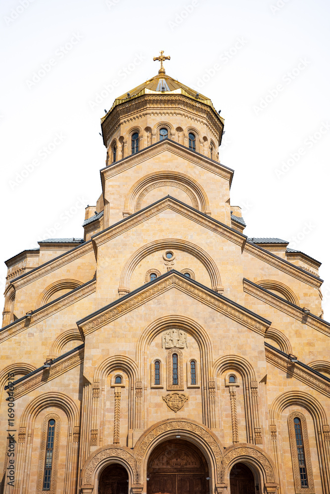 Fototapeta premium A striking view of the Holy Trinity Cathedral of Tbilisi, known as Sameba Cathedral. The golden dome, ornate arches, and detailed stone carvings highlight the beauty of Georgian Orthodox architecture