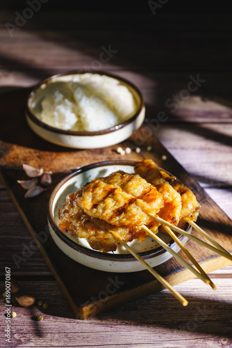 Moo ping grilled pork skewers with sticky rice on a restaurant table