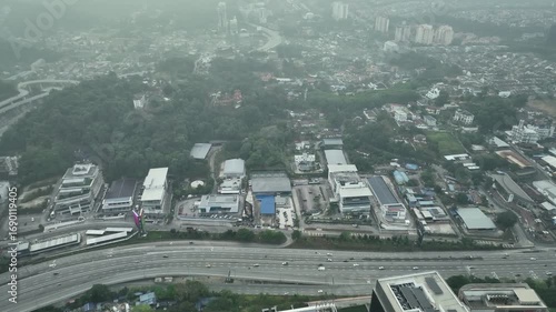 Scenic Aerial View of a Busy Highway Surrounded by Urban Landscape in July Under Overcast Sky