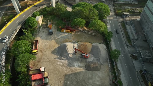 Aerial View of a Highway Intersection with Construction Site and Greenery in Urban Environment in July