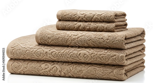 Elegantly folded stack of luxurious floral pattern towels in neutral tan tone isolated on white