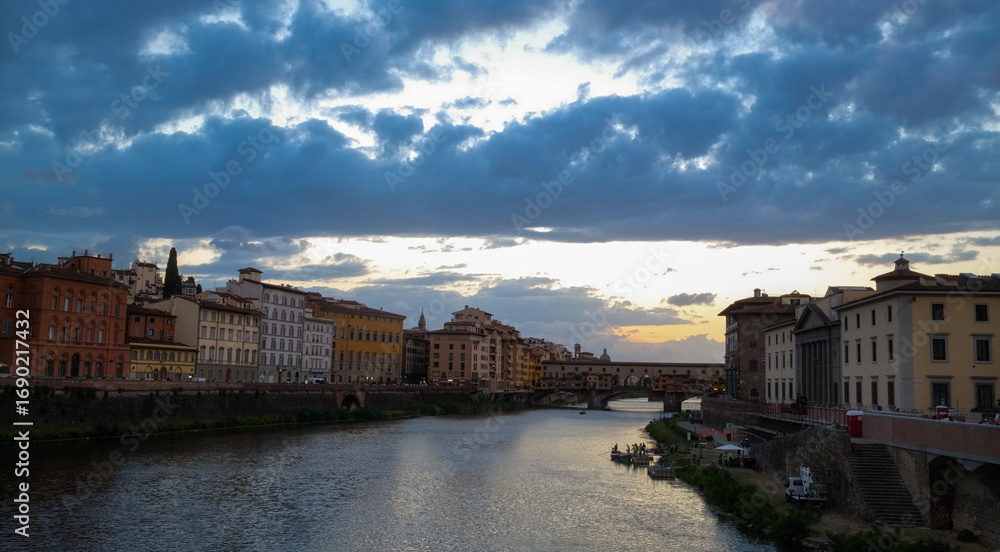 Fototapeta premium Florence, Italy – view of the Arno River with historic buildings along the riverside and Renaissance architecture reflecting in the water.