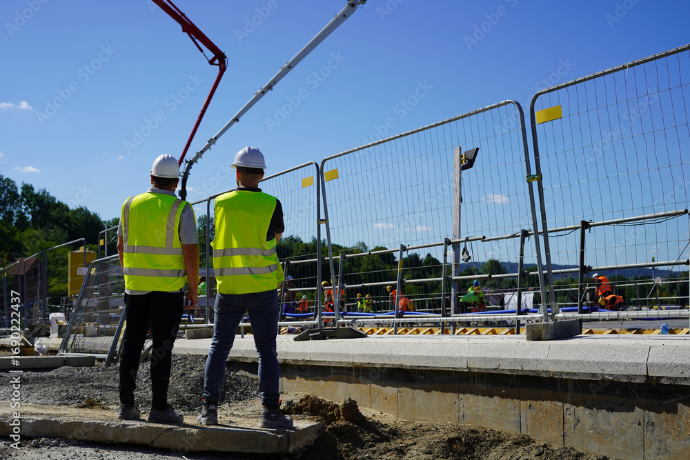 Fototapeta premium Engineers from back overseeing construction site progress