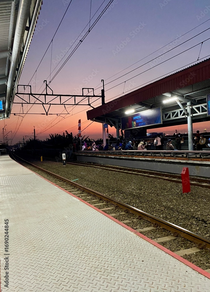 Fototapeta premium Railway Station at Sunset with Purple and Orange Sky