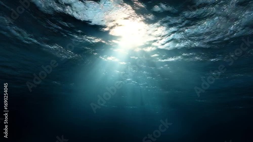 Sunlight piercing through the surface of deep ocean water, creating visible rays and a serene underwater atmosphere. 4K video