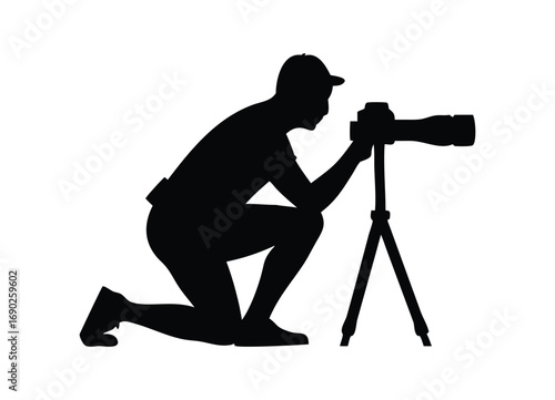 Silhouette of a photographer kneeling with a camera on a tripod capturing a moment