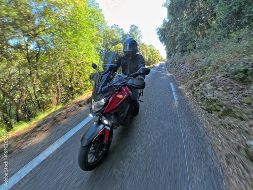 Motard roulant vite sur une route de campagne