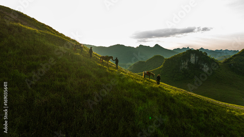Fotografija Dawn on the high mountain peaks of Ha Lang area, with pack horses and people going to work