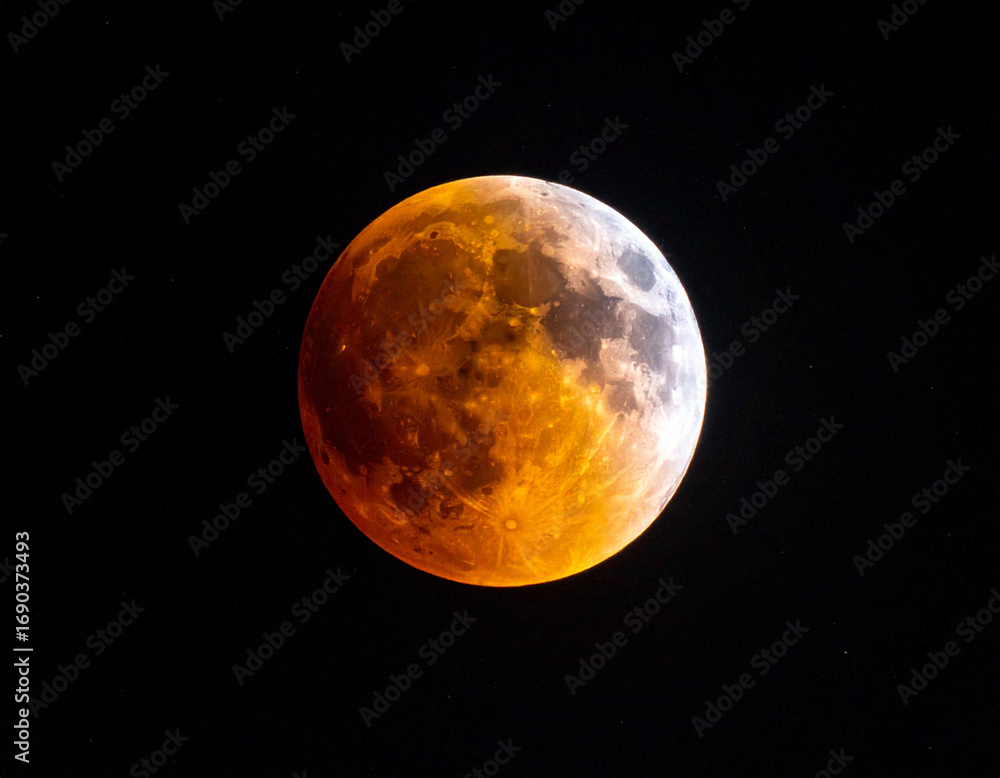 Fototapeta premium Lunar eclipse with reddish orange glow