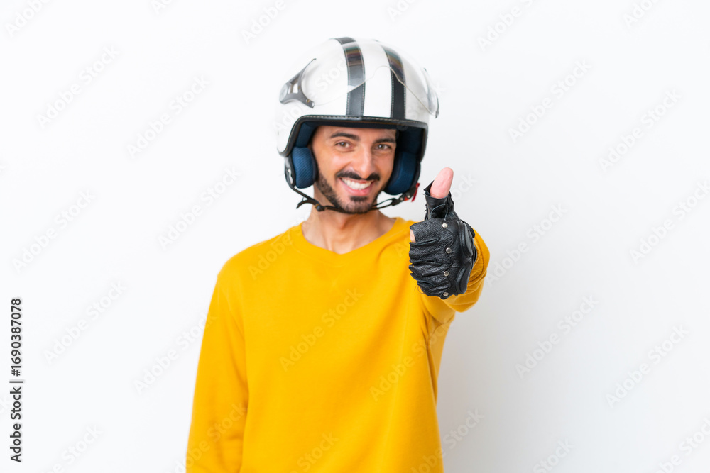 Naklejka premium Young caucasian man with a motorcycle helmet isolated on white background with thumbs up because something good has happened
